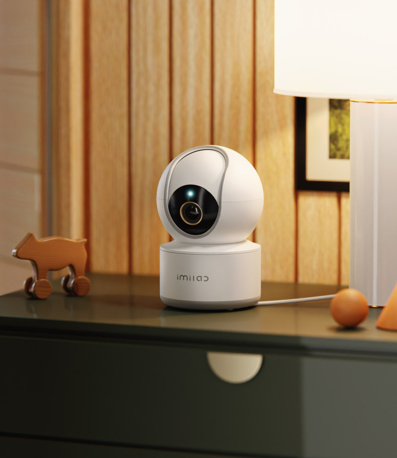 white-mini-round-surveillance-camera-on-dark-green-bed-side-table-with-wooden-cow-toy-beside-it